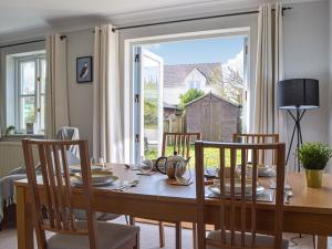 a dining room with a table and chairs and a window at Goslings in Marloes