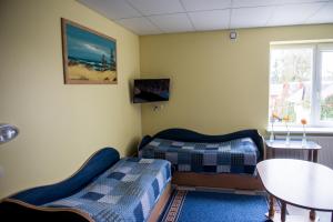 a living room with two beds and a table at Eiva in Marijampolė