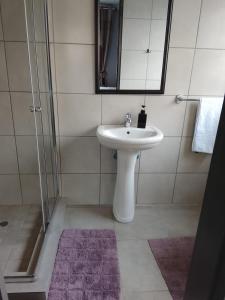 a white bathroom with a sink and a mirror at Phapel Home-Away in Pretoria +30 photos