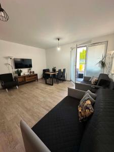a living room with a black couch and a television at APARTAMENT Z TARASEM STELLA in Sanok
