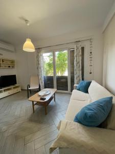 a living room with a couch and a table at Renissa's Beach Suite in Vlorë