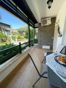 a room with a table and chairs and a balcony at Renissa's Beach Suite in Vlorë