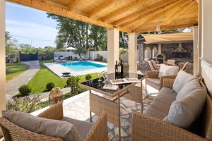 a patio with wicker furniture and a swimming pool at Pavlos & Sofia Harmony Villa with Private Pool in Corfu
