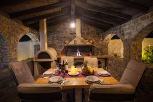 a dining room with a table and a fireplace at Pavlos & Sofia Harmony Villa with Private Pool in Corfu