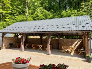 a wooden pavilion with tables and chairs and flowers at Apartamenty w Kotlinie in Lądek-Zdrój