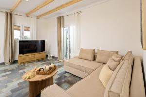 a living room with a couch and a tv at Pavlos & Sofia Harmony Villa with Private Pool in Corfu