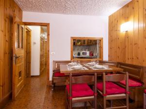 a dining room with a wooden table and red cushioned chairs at Apartment Casa Rossa by Interhome in Madesimo +32 photos