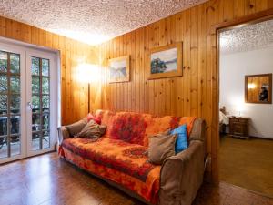 a living room with a couch and wooden walls at Apartment Casa Rossa by Interhome in Madesimo