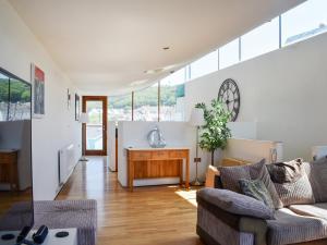 a living room with a couch and a clock on the wall at The Balcony in Westward Ho