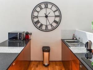 a kitchen with a large clock on the wall at The Balcony in Westward Ho +8 photos