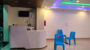 two blue chairs sitting next to a counter in a room at Hotel bandana residency in Rājgīr
