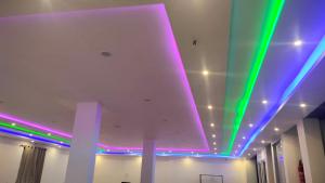 a room with purple and green lights on the ceiling at Hotel bandana residency in Rājgīr