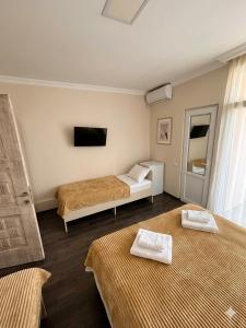 a hotel room with two beds and a tv at Guest House Kobuleti 516 in Kobuleti
