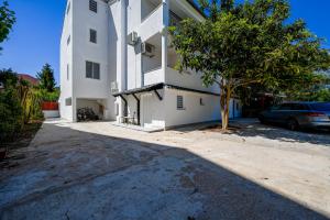 a white building with a tree in front of it at Gasparevic Apartments in Rovinj