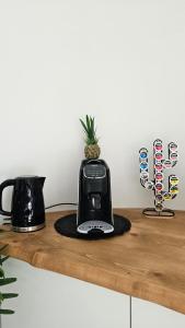a black toaster sitting on top of a wooden shelf at MarEden Sicily Room , Relax e Bonsai in Favara
