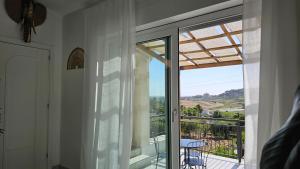 a room with a glass door leading to a balcony at MarEden Sicily Room , Relax e Bonsai in Favara