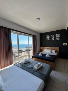 a hotel room with two beds and a large window at Apartments Adriatik in Ulcinj