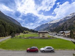 two cars parked in a parking lot with mountains in the background at Apartment Casa Cavalieri by Interhome in Valdisotto