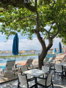 a group of tables and chairs next to a pool at Ayvalık Denizyıldızı Otel in Ayvalık