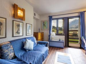 a living room with a blue couch and a window at Apartment Casa Cavalieri by Interhome in Valdisotto
