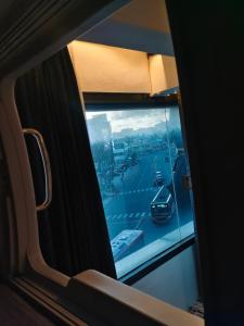 a view of a street from a window on a train at TRIVPODS Capsule Hotel in Trivandrum +6 photos