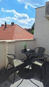 a patio with a table and chairs on a balcony at Gabipapi in Pécs +3 photos
