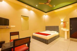 a bedroom with a bed and a flat screen tv at KINGS RESORT DANDELI in Dandeli