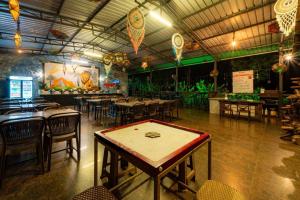 a restaurant with tables and chairs in a room at KINGS RESORT DANDELI in Dandeli