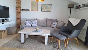 a living room with a couch and a table and a chair at Meerferienwohnungen Kühlungsborn in Kühlungsborn
