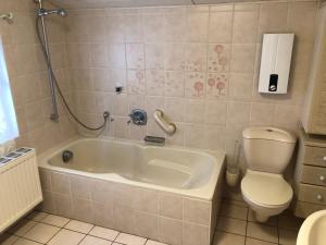 a bathroom with a tub and a toilet and a sink at Casa Müller in Lissendorf +29 photos