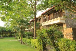 a building with a balcony on the side of it at The Corbett Manral Resort in Rāmnagar