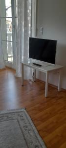 a white table with a tv on it in a living room at Ferienwohnung Gartentraum in Oberzent