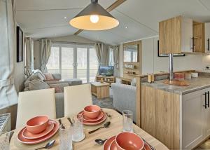a kitchen and living room with a dining table and a living room at Trossachs Holiday Park in Gartmore
