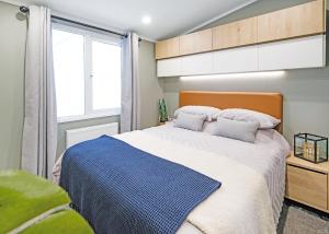 a bedroom with a large bed and a window at Trossachs Holiday Park in Gartmore