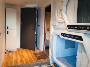 a kitchen with a stove and a door to a bathroom at TRIVPODS Capsule Hotel in Trivandrum