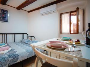 a room with a table and a bed with dishes on it at Studio Piccolo Mondo by Interhome in Lovran