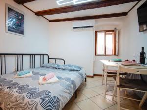 a bedroom with a bed and a table with towels on it at Studio Piccolo Mondo by Interhome in Lovran +16 photos