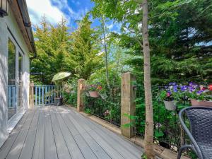 a wooden deck with potted plants and a fence at Fronfanol - Uk49776 in Llanfair Talhaiarn