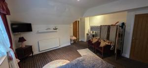 a living room with chairs and a tv in a room at Island House in Lanercost