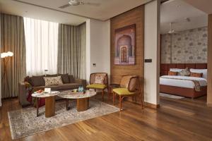 a hotel room with a bed and a living room at Triptam Vrindavan in Vrindāvan +57 photos