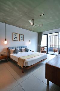 a bedroom with a large bed and a large window at E.05 City Inn in Alwaye +119 photos