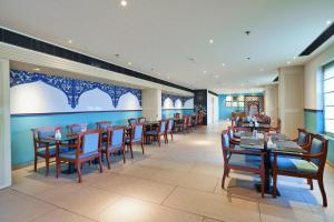 a dining room with wooden tables and chairs at E.05 City Inn in Alwaye