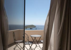 a balcony with a table and chairs and the ocean at Monte Vista Lemnos Apartments in Myrina