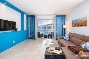 a living room with a couch and a tv at The Terraces Seafront Getaway Malta 3 Bedroom Apartment in St. Paul's Bay