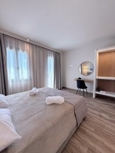 a bedroom with a large bed with towels on it at Monte Vista Lemnos Apartments in Myrina