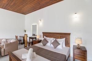 a bedroom with a bed and a couch and a chair at Mihira Gedara Apartments in Unawatuna +70 photos