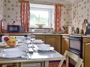 a kitchen with a table with a bowl of fruit on it at Waterfall Cottage in Glendale