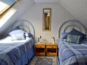 two beds sitting next to each other in a bedroom at Waterfall Cottage in Glendale