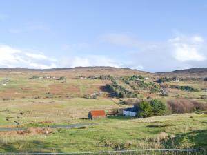 a field with a farm in the middle of a hill at Waterfall Cottage in Glendale