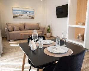 a dining room with a black table and chairs at Monte Vista Lemnos Apartments in Myrina